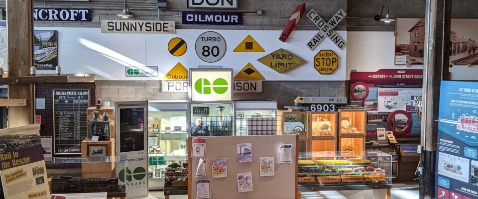 Celebrate International Museum Day with the Toronto Railway Museum! Image shows busy interior of the museum with many railway signs, exhibits and drawings.