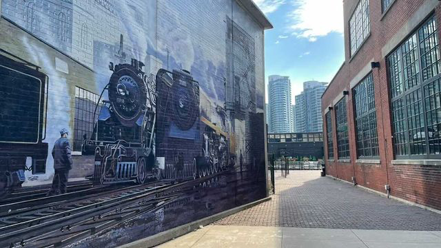 Side-ong view of a mural wall of two steam locomotives